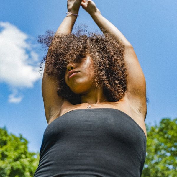 Energetic woman stretching outdoors, feeling vibrant and full of life.